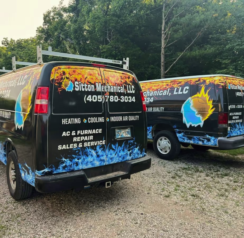 Two fire-and-ice wrapped Sitton Mechanical service vans parked in Stillwater, Oklahoma